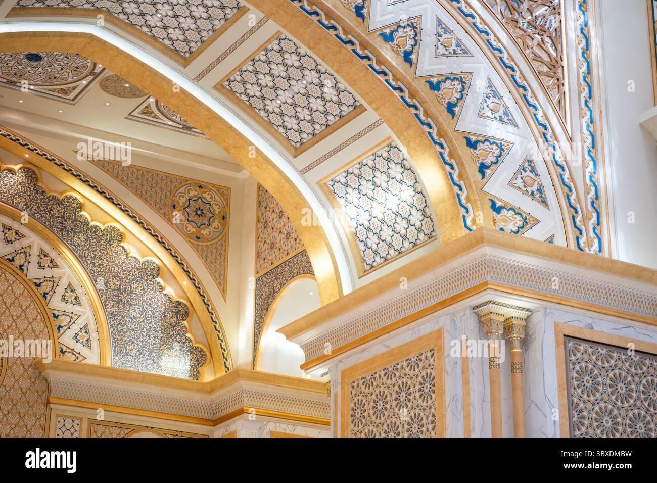 Dettagli architettonici intricati con motivi ornati e archi dorati in un ambiente interno opulento Foto Stock