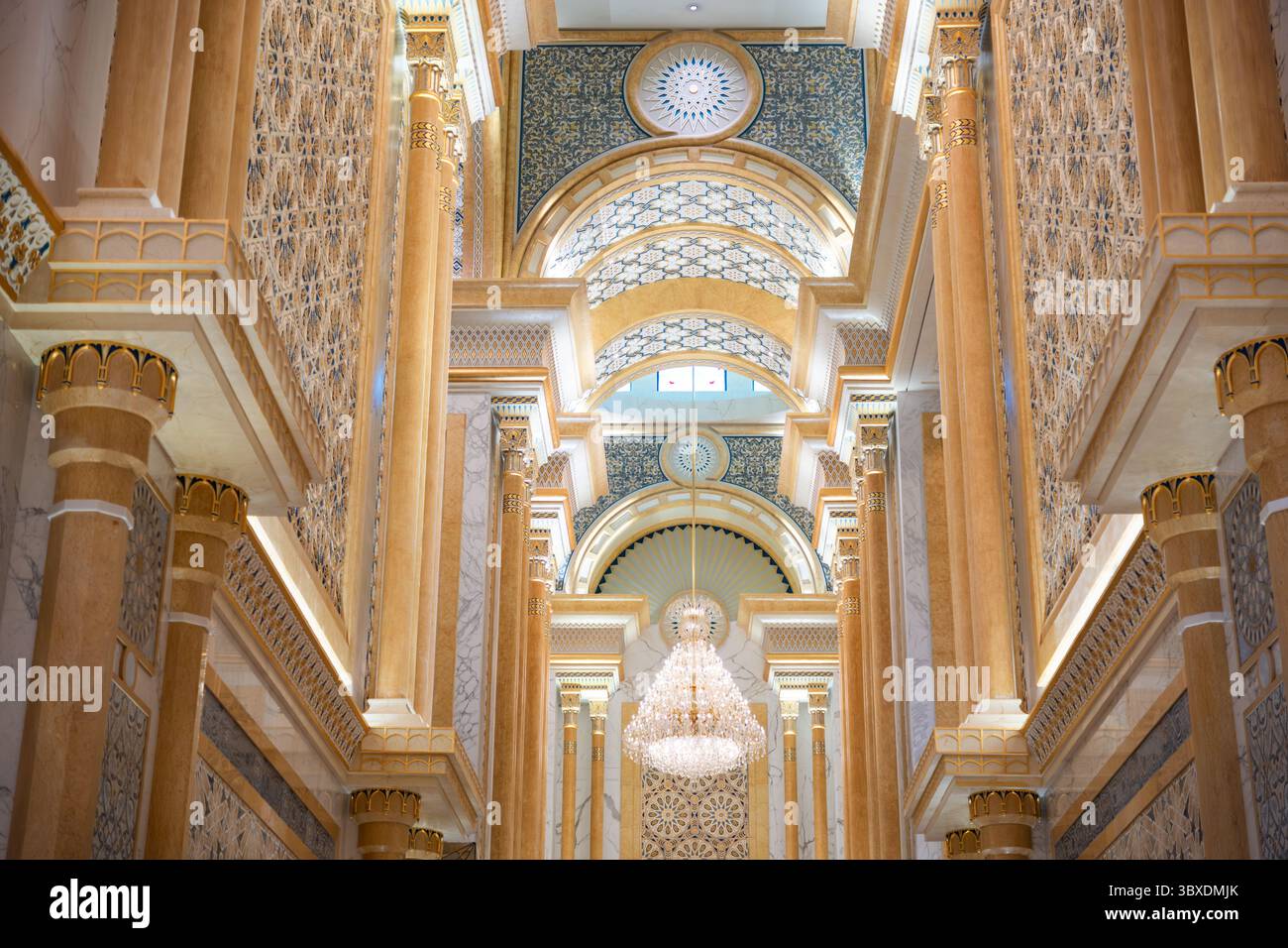 Soffitto decorato con grandi archi e lampadari in un sontuoso spazio interno. Colonne in marmo e motivi intricati aggiungono un tocco di opulenza all'arredamento Foto Stock