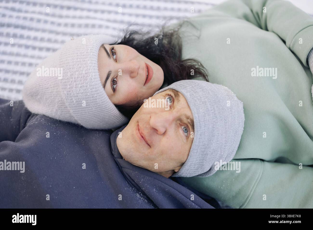 Coppia felice che gioca a partita invernale nella foresta all'aperto. Concetto di amore e tempo libero. Foto Stock