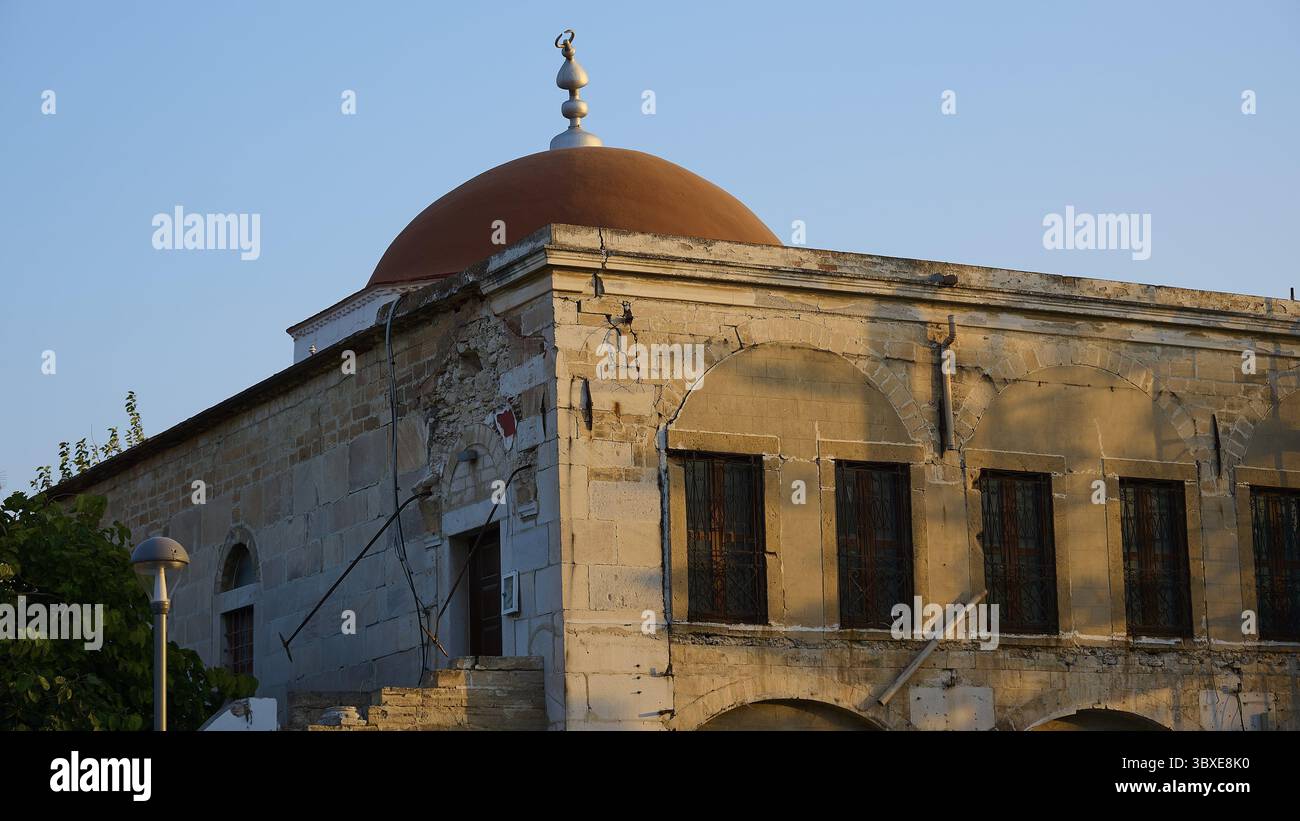 Moschea Defter-dar, Piazza Eleftherias, edificio storico con cupola rossa e vecchie mura di pietra alla luce soffusa del sole, Kos Town, Kos, Dodecaneso, Isla greca Foto Stock