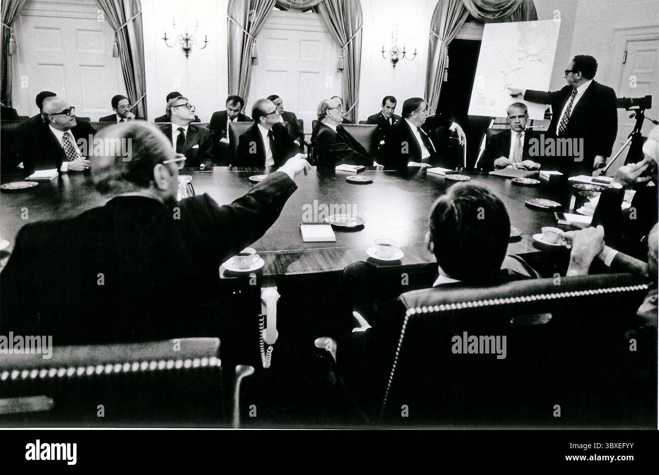 15 maggio 1975 - Washington, Distretto di Columbia, USA - il presidente degli Stati Uniti GERALD R. FORD sottolinea ai leader del Congresso come il Segretario di Stato degli Stati Uniti HENRY KISSINGER indica una mappa della Cambogia durante un briefing della Casa Bianca sulla situazione di Mayaguez a Washington, D.C. il 15 maggio 1975. Il Segretario alla difesa degli Stati Uniti JAMES SCHLESINGER siede di fronte alla mappa. Seduto alla destra del presidente Ford, con le spalle alla telecamera, è il presidente della camera CARL ALBERT (Democratico dell'Oklahoma). (Immagine di credito: © David Hume Kennerly/The White House/ZUMA Wire/ZUMAPRESS.com) Foto Stock