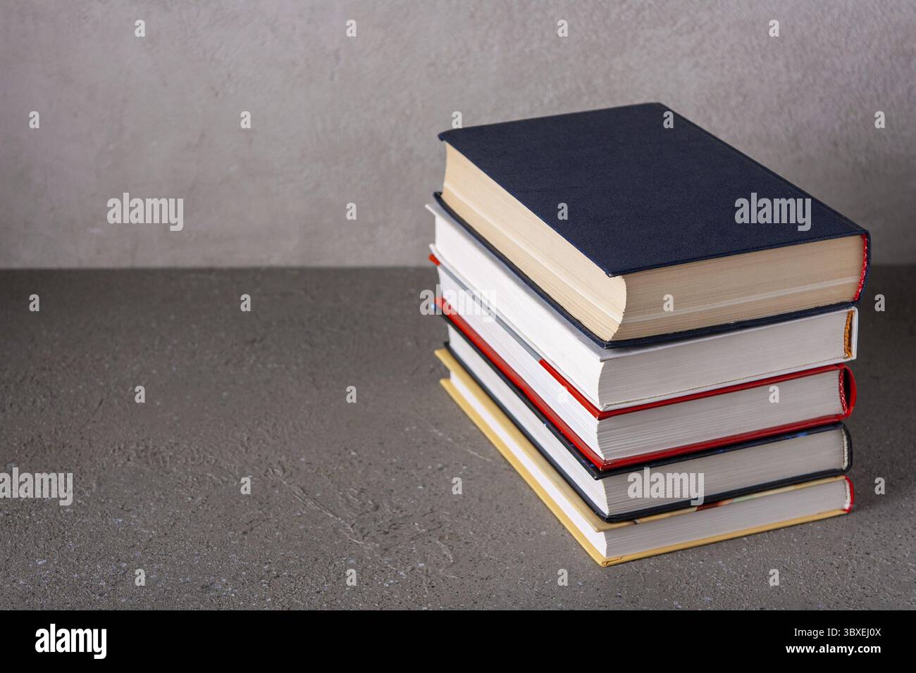 Una pila di libri di finzione giace su un tavolo grigio Foto Stock