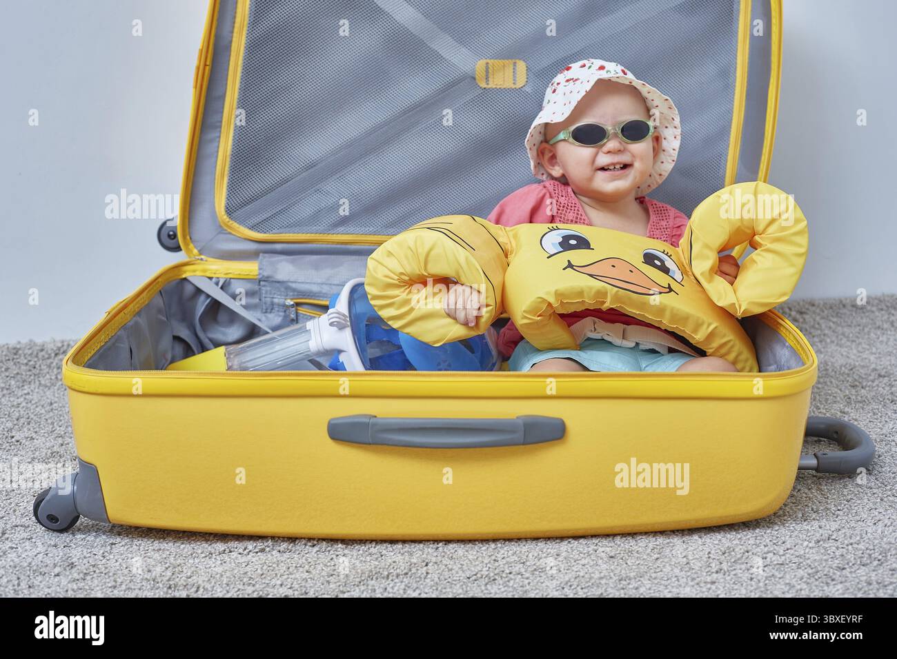 Bambino in valigia con oggetti per una vacanza al mare o un viaggio in vacanza Foto Stock