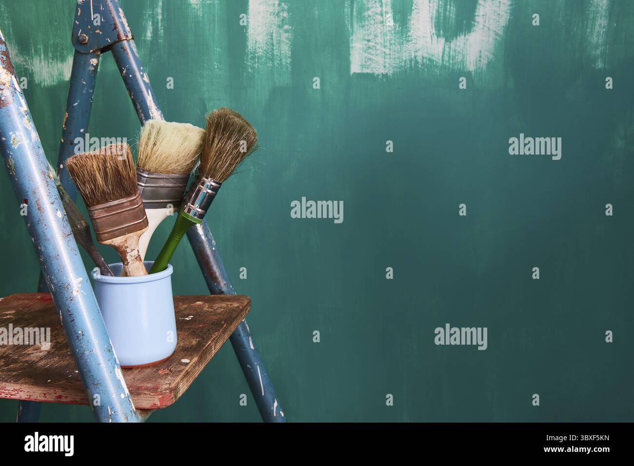 Sfondo per il testo sulla riparazione e la pittura delle pareti nell'appartamento. Tasselli e scala su sfondo verde. Spazio di copia Foto Stock