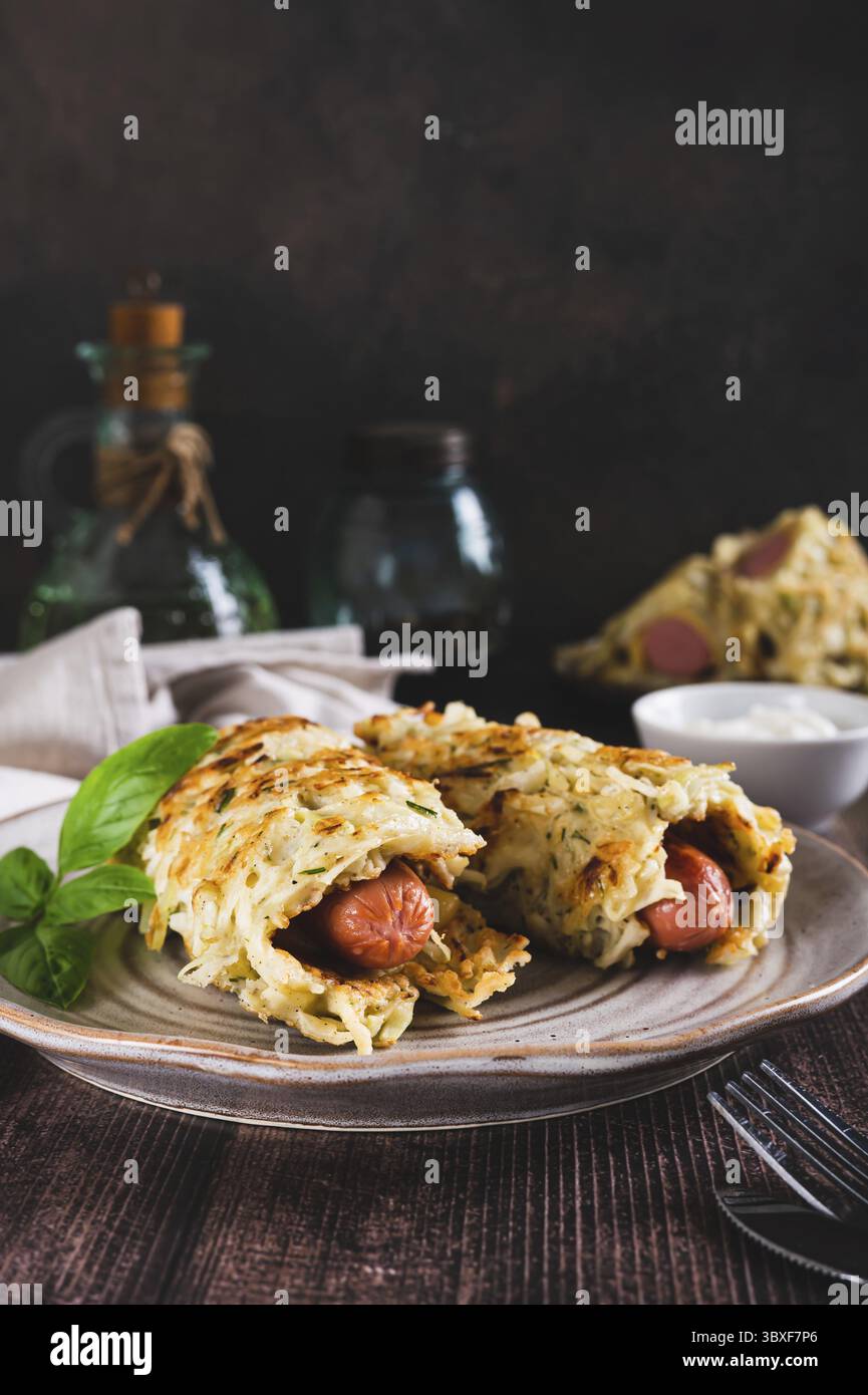 Cibo, salsicce avvolte in pancake di cavolo tagliati su un piatto con vista verticale Foto Stock