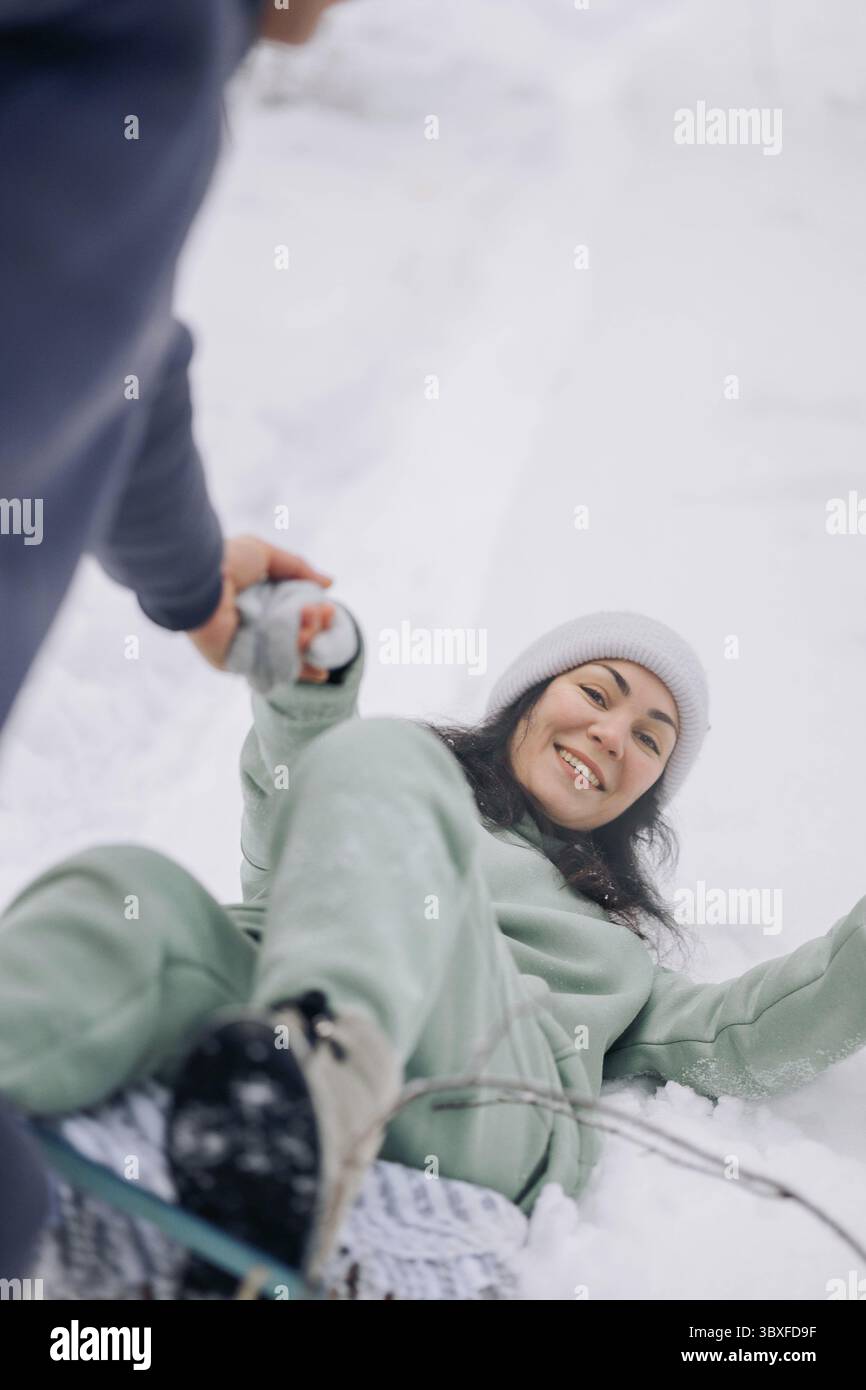 Coppia felice che gioca a partita invernale nella foresta all'aperto. Concetto di amore e tempo libero. Foto Stock