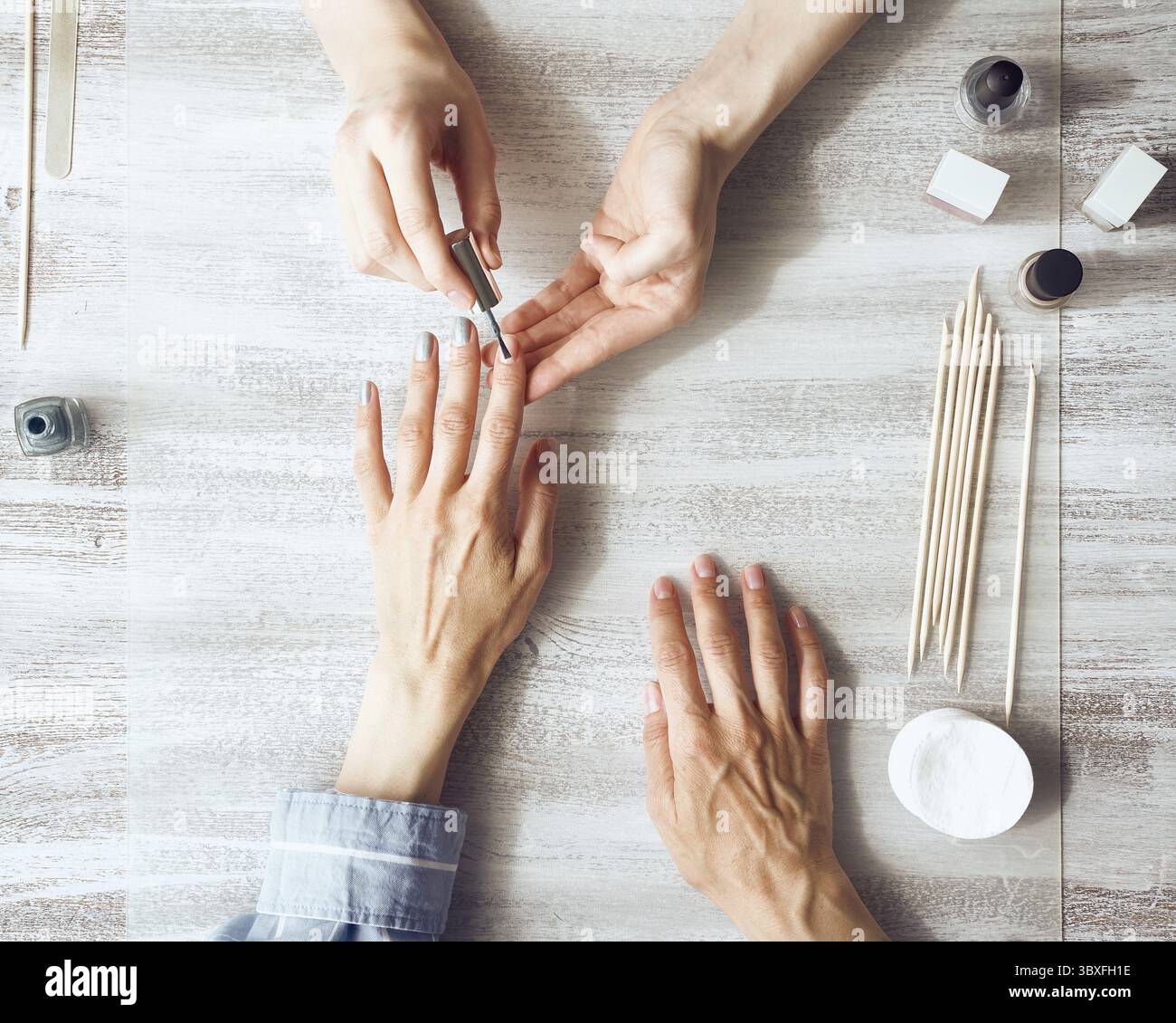 Madre e figlia fanno manicure, dipingono le unghie con vernice. Assistenza domiciliare durante la quarantena, autoisolamento. Vista dall'alto del tavolo Foto Stock Madre e figlia fanno manicure, dipingono le unghie con vernice. Assistenza domiciliare durante la quarantena, autoisolamento. Vista dall'alto del tavolo Foto Stock