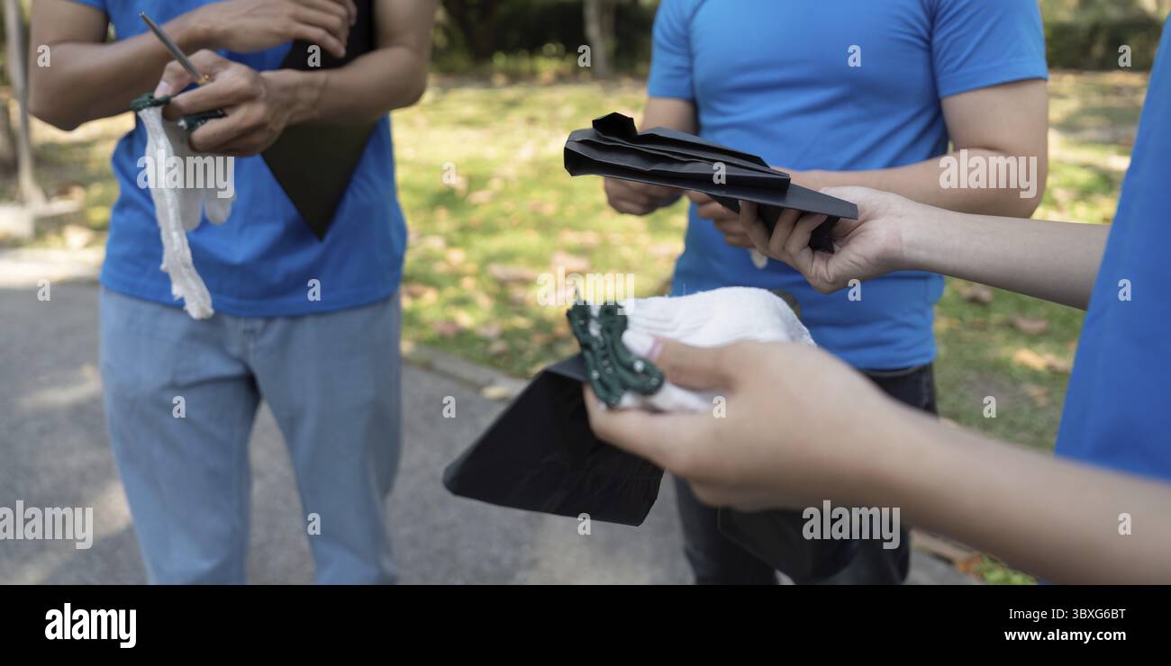 Giovani volontari dotati di provviste che discutono dei piani per una prossima bonifica ambientale, simboleggiando il loro impegno per la sostenibilità Foto Stock