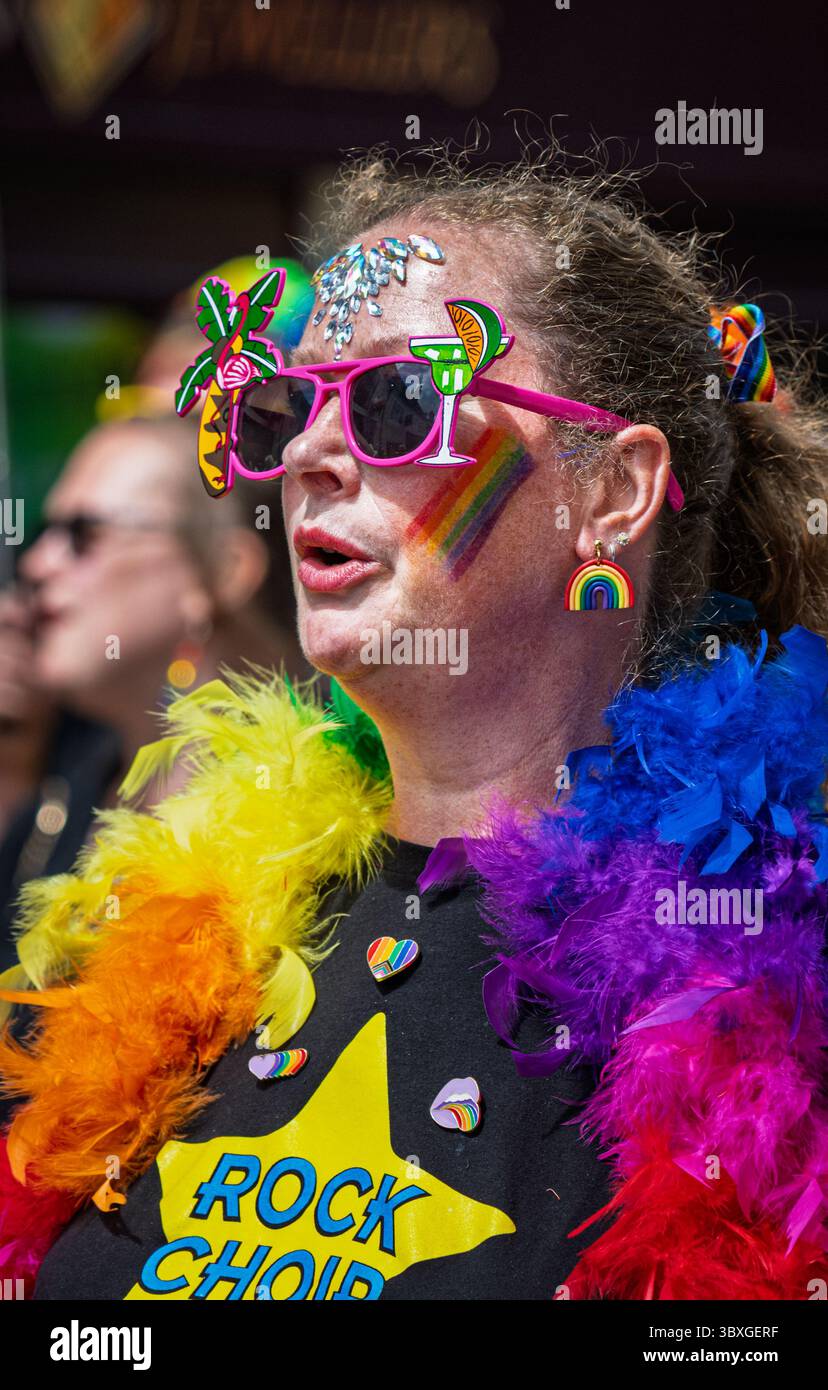 Sherborne Pride mette in mostra un vivace raduno dove i partecipanti esprimono gioia attraverso abiti colorati, accessori e pittura del viso durante le celebrazioni Foto Stock