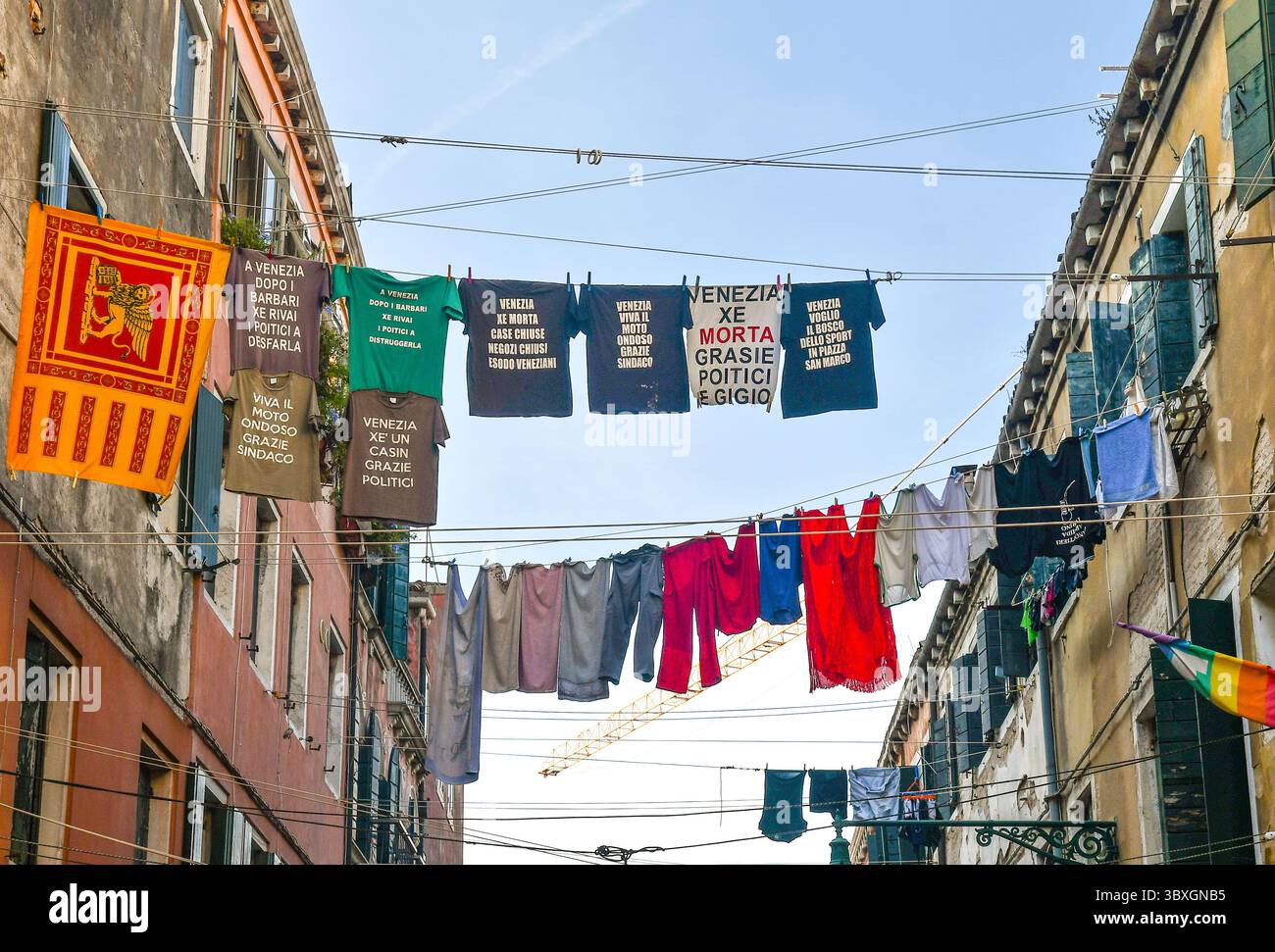 Vista a basso angolo della maglietta di protesta contro i politici veneziani, appesa a clothesline in Corte nuova, quartiere Castello, Venezia, Veneto, Italia Foto Stock
