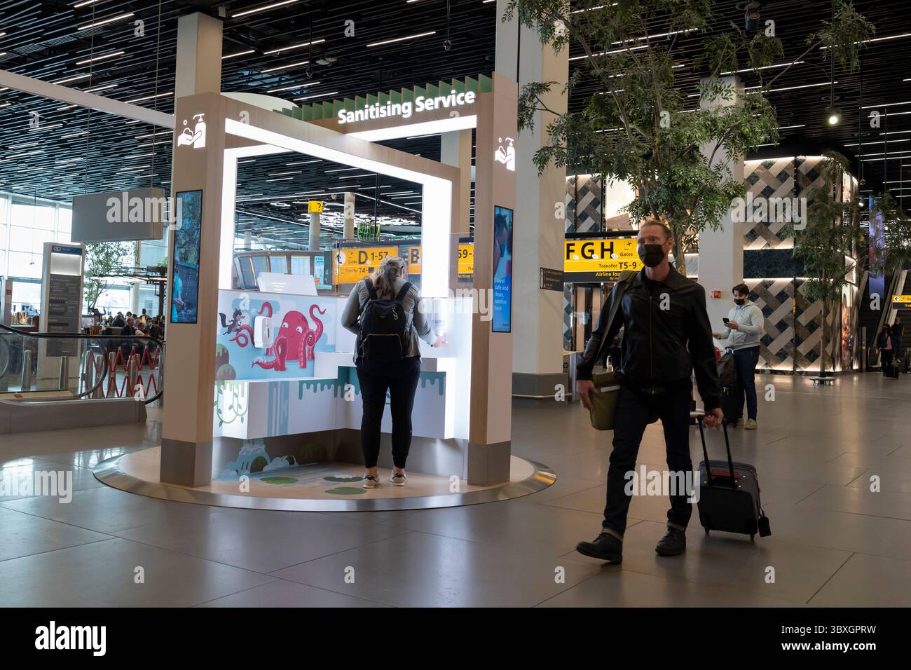 26 agosto 2021, Amsterdam, Olanda settentrionale, Paesi Bassi: Un passeggero utilizza un punto di servizio igienizzante presso l'aeroporto di Amsterdam Schiphol, Paesi Bassi. Le nuove stazioni igieniche consentono ai passeggeri di disinfettare queste mani e di disinfettare i loro effetti personali con UV-C.. (Immagine di credito: © Paul Christian Gordon/ZUMA Press Wire) Foto Stock
