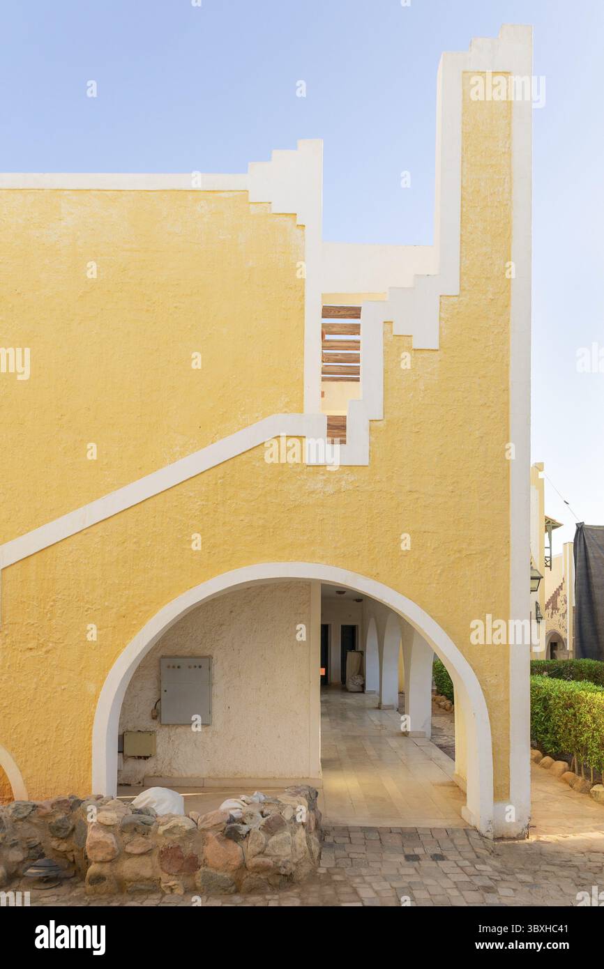 Esterno della casa in stile orientale. Architettura tradizionale, antica casa araba gialla con archi e scale in stile minimalista, Sharm El Sheikh, Egy Foto Stock