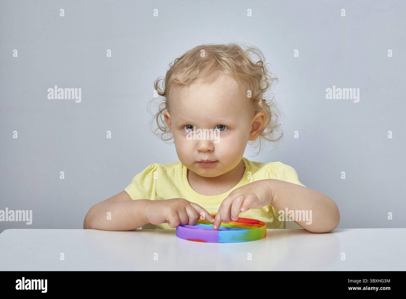 Popolare giocattolo anti stress Pop it. Bambino che gioca con il giocattolo Pop IT Fidget. Felice infanzia, giochi educativi popolari Foto Stock