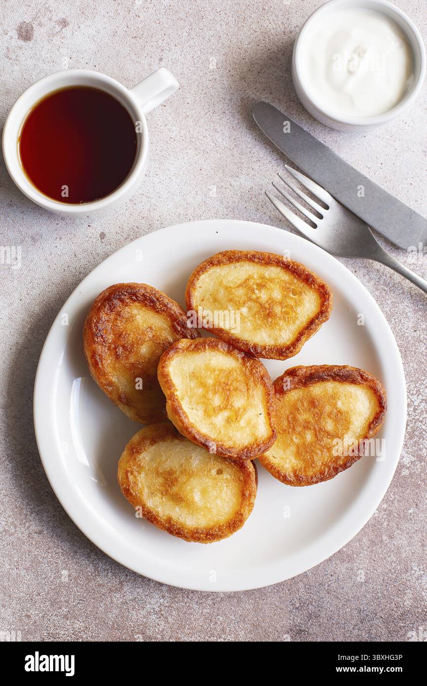 Soffici pancake Flapjack. Frittelle fritte con panna acida e marmellata. Sana colazione tradizionale. Menu per bambini. Ricetta per pancake soffici. COM. Piatto Foto Stock