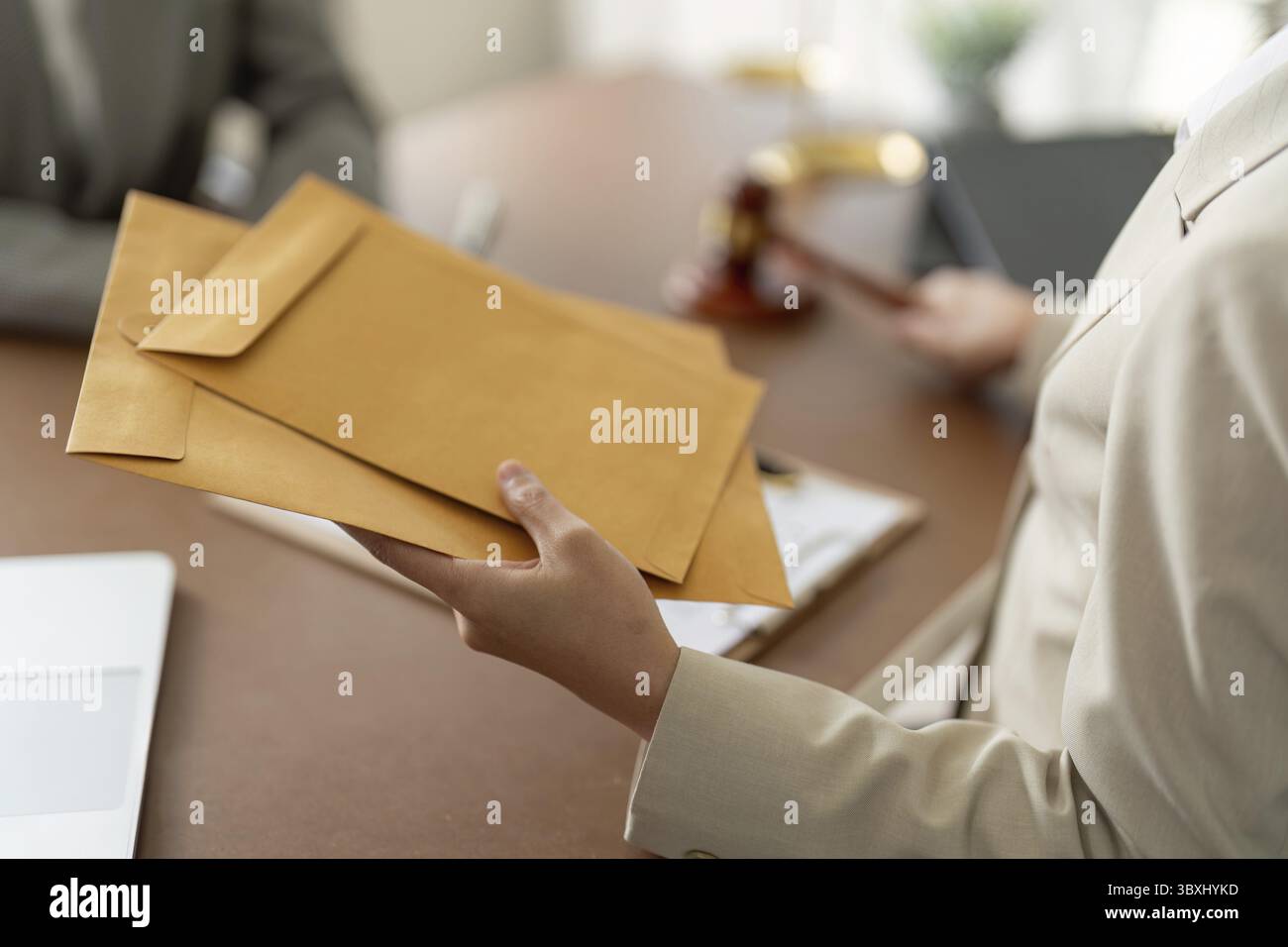 Un consulente legale che consegna i documenti a un cliente, evidenziando lo scambio legale riservato e il servizio professionale Foto Stock