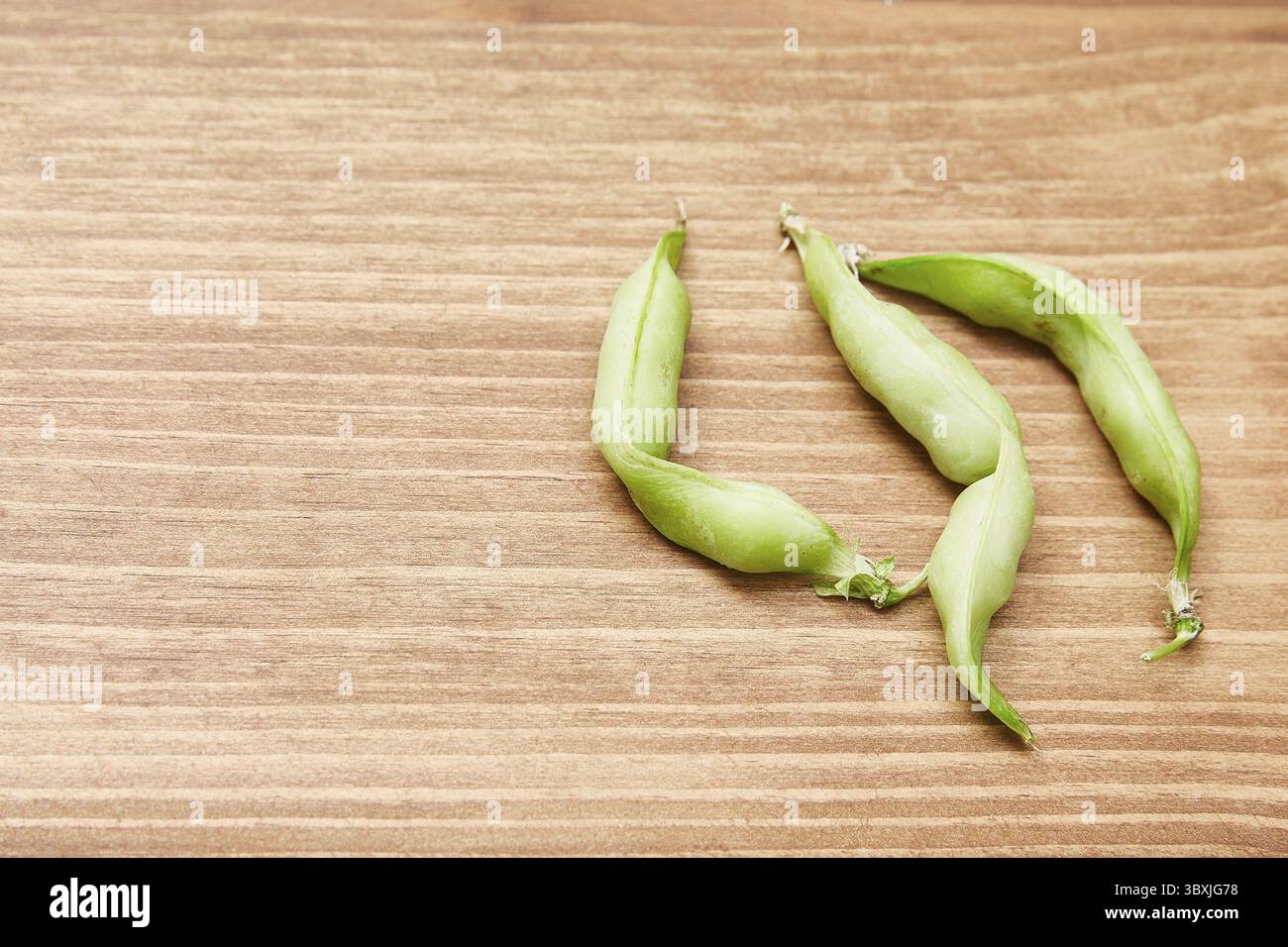 Brutti piselli biologici coltivati in casa su sfondo di legno. Cibo brutto e alla moda. Vista dall'alto, spazio fotocopie Foto Stock