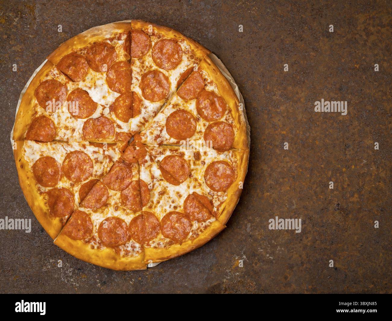 Runde italienische Pizza pepperoni auf einem rostigen Metalltisch Top-Ansicht, leerer Platz fuer Text Foto Stock