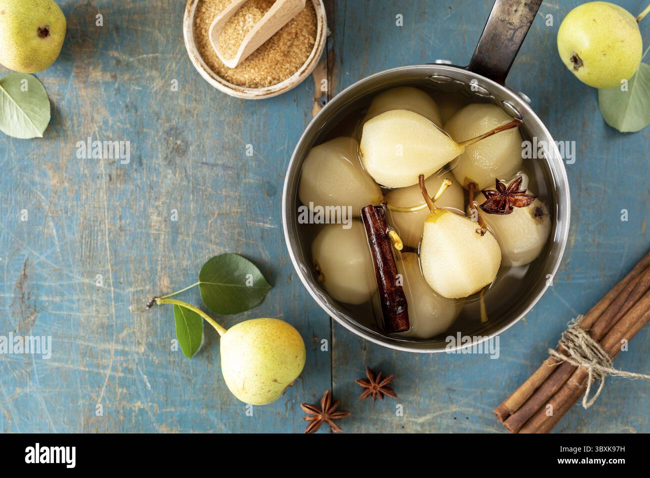 Cibo, pere in camicia con spezie sciroppate su fondo di legno blu. Delizioso dessert per le vacanze Foto Stock