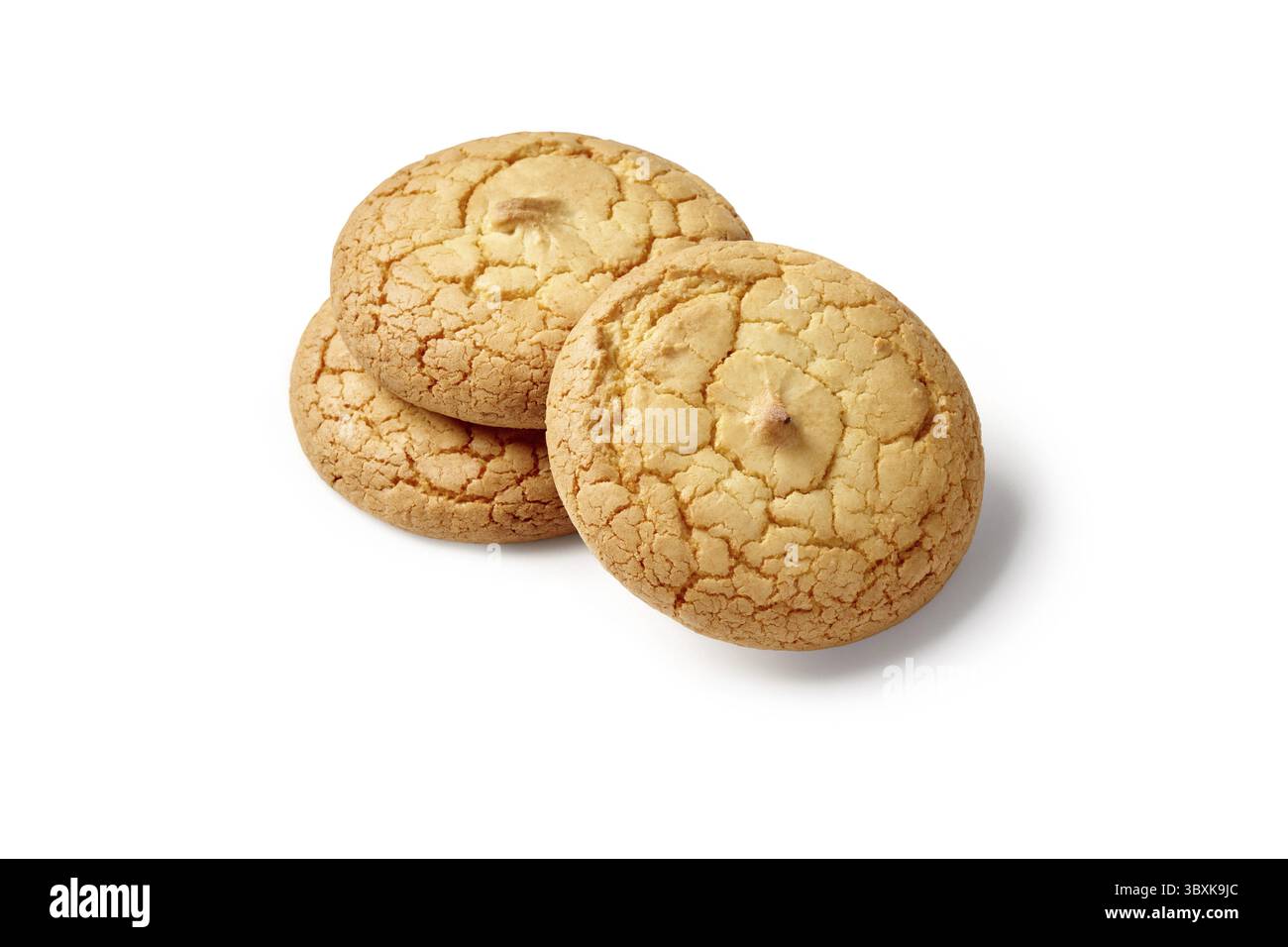 Tre biscotti amaretti dorati, freschi e invitanti, seduti su una superficie bianca incontaminata Foto Stock