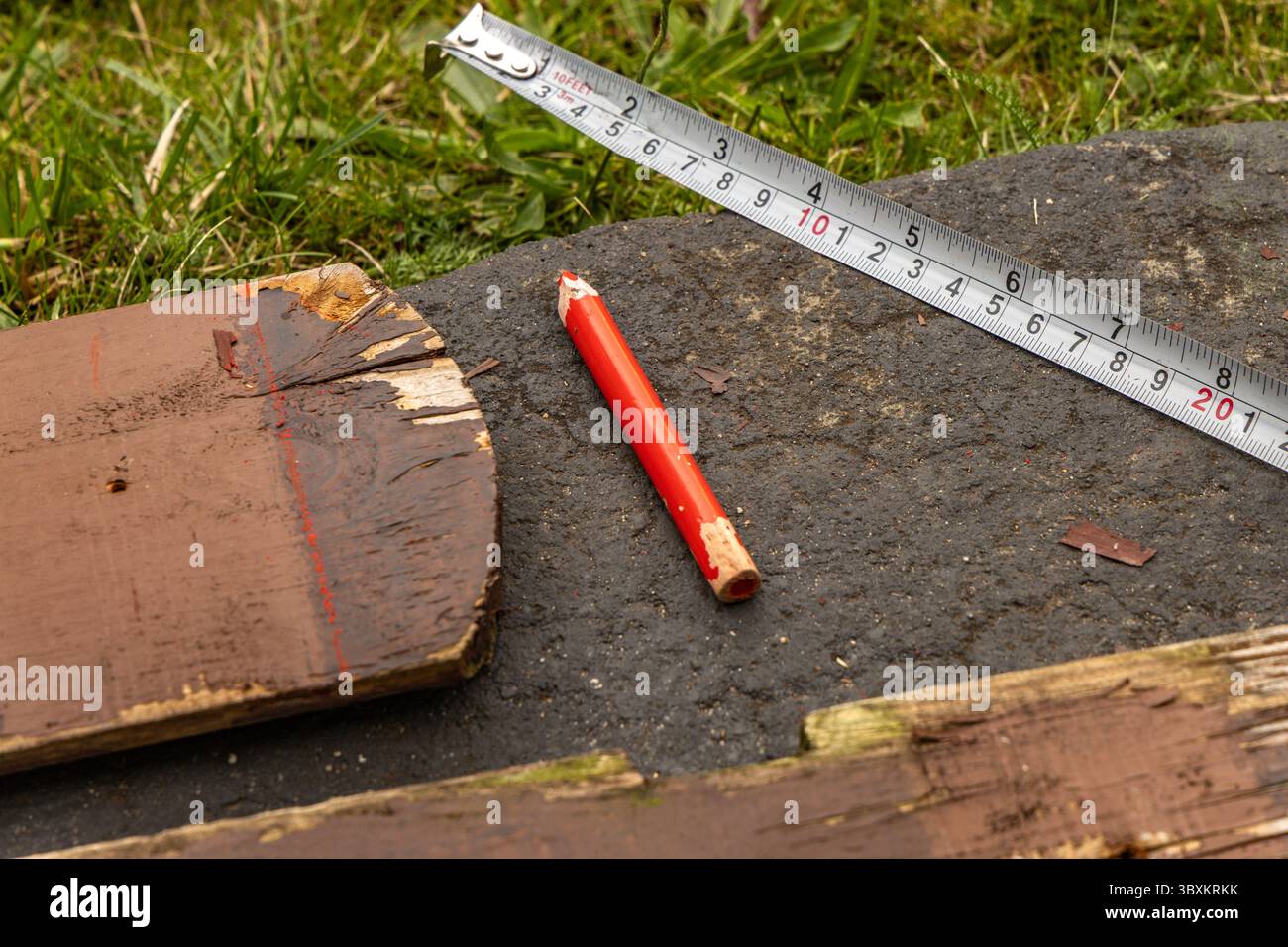 Matita da disegno rossa, metro a nastro, cartone, costruzione di mobili da giardino in legno, pergola Foto Stock