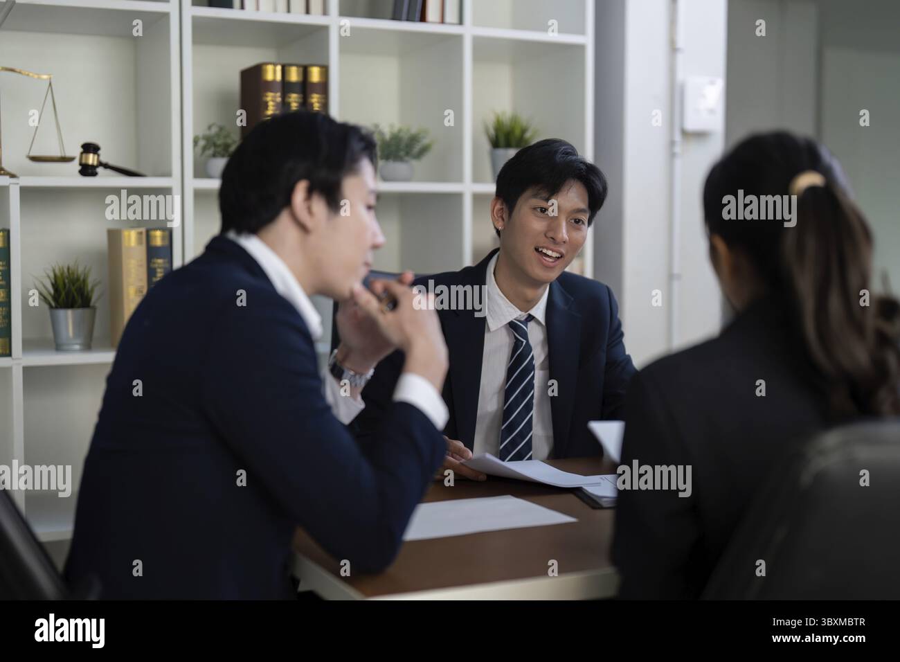 Due avvocati discutono un caso in dettaglio, dimostrando impegno e lavoro di squadra mentre preparano le loro strategie legali in un contesto professionale Foto Stock