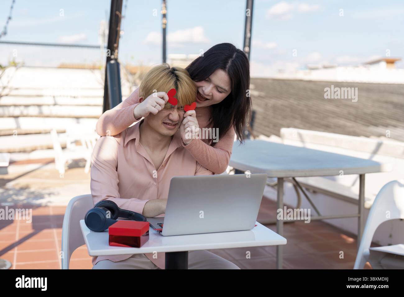 Una coppia festeggia con gioia San Valentino insieme su un tetto abbracciando amore e connessione in un ambiente sereno Foto Stock