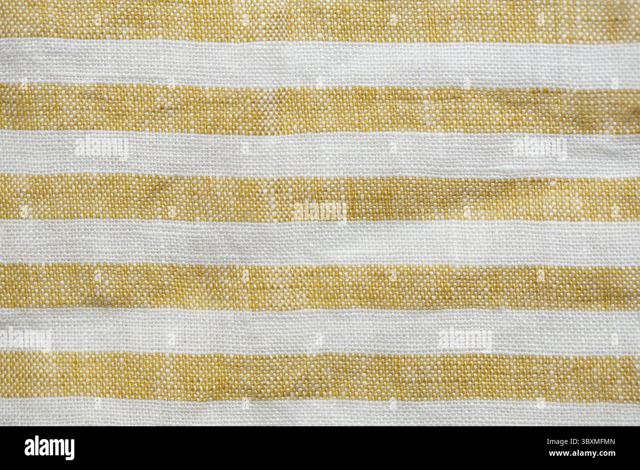 Tessuto a righe giallo e bianco con una trama rustica e intrecciata. Un motivo naturale e senza cuciture, ideale per sfondi, tessuti o disegni decorativi Foto Stock