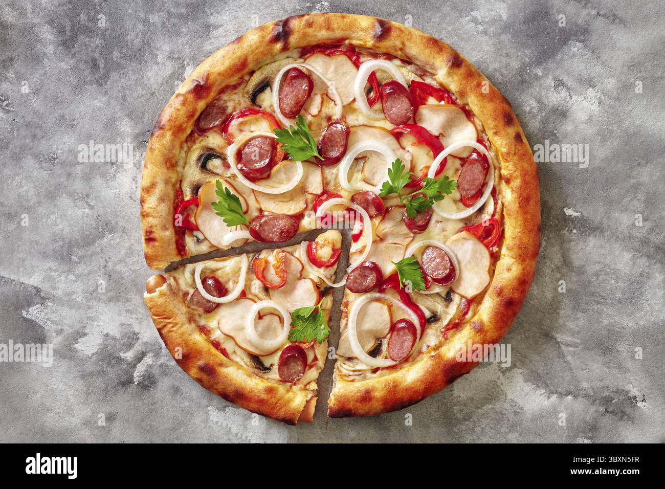 Vista dall'alto della pizza a fette con bordo dorato ripieno di salsicce viennesi e ripieno di mozzarella, pollo affumicato, salsicce di caccia, funghi, campanella Foto Stock