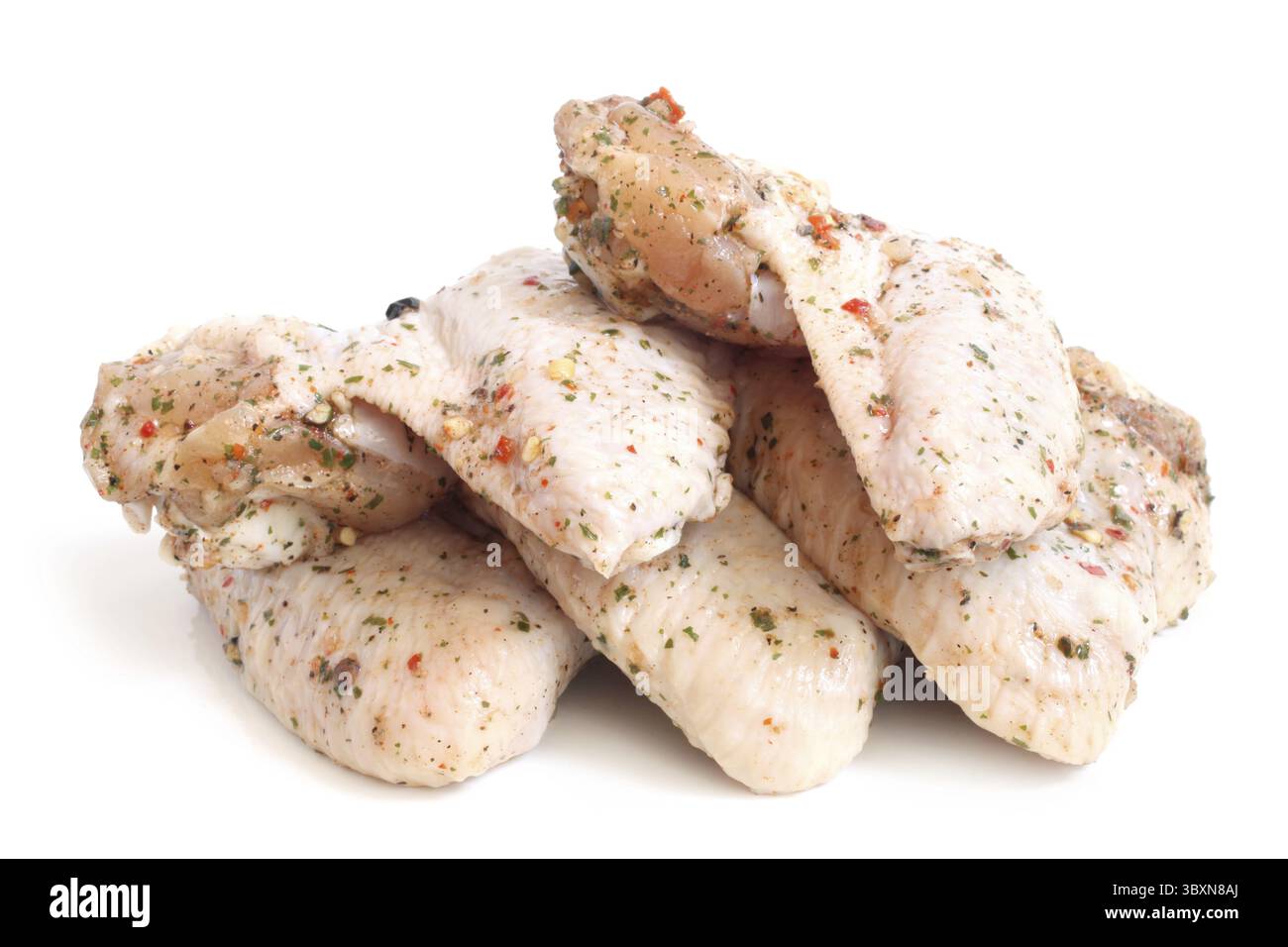 Ali di pollo crude con condimenti su sfondo bianco Foto Stock
