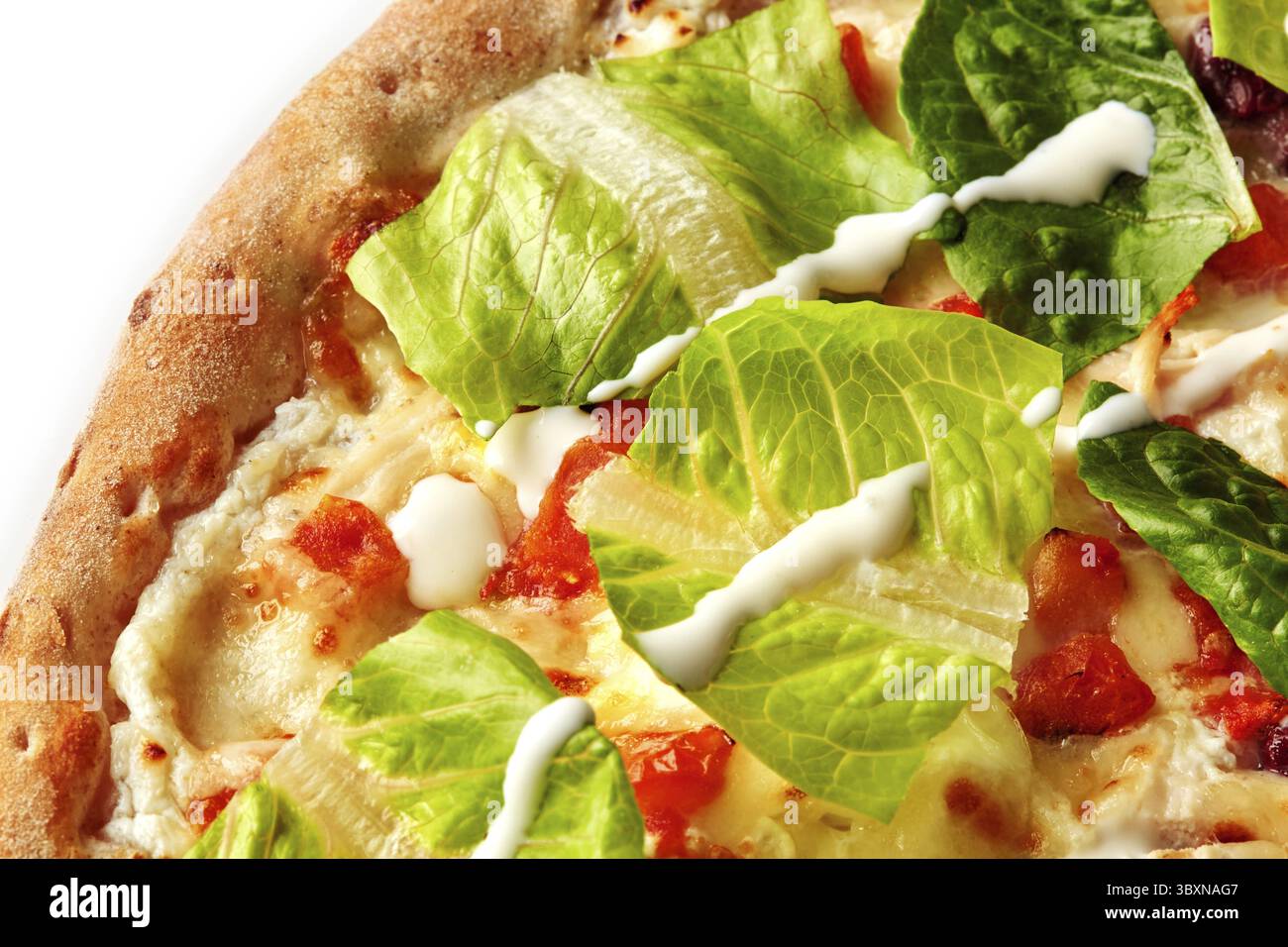 Primo piano dell'appetitosa pizza caesar con lattuga romaina fresca, condimento cremoso e condimenti saporiti Foto Stock