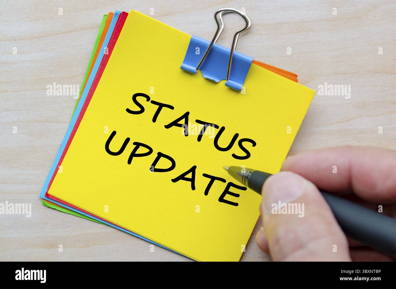 Testo aggiornamento stato su blocco note giallo. Aggiornamenti aziendali e informazioni sullo stato Foto Stock
