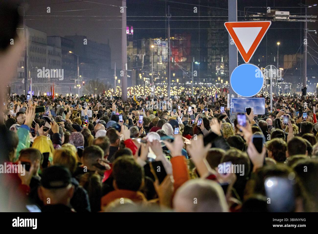 Belgrado, Serbia - 15 marzo 2025: Molte persone sollevano mano in alto tengono il cellulare, cellulare con torcia, luce in onore delle vittime, 15 minuti di silenzio Foto Stock