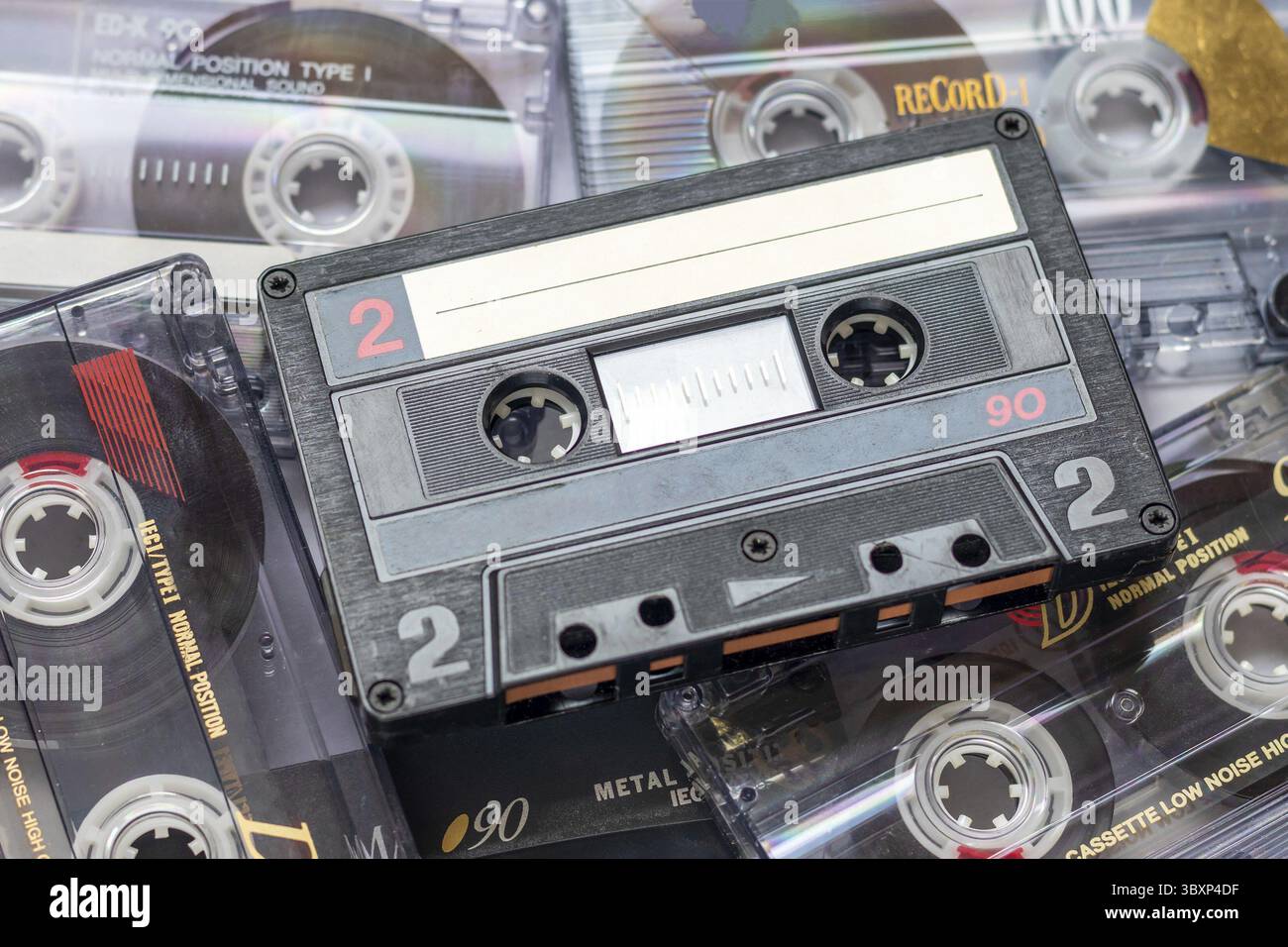 Un nastro per audiocassette appoggiato su una pila di audiocassette sovrapposte Foto Stock