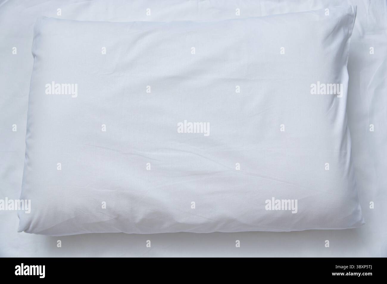 Vista dall'alto di un cuscino bianco su un foglio bianco. Spazio di copia Foto Stock