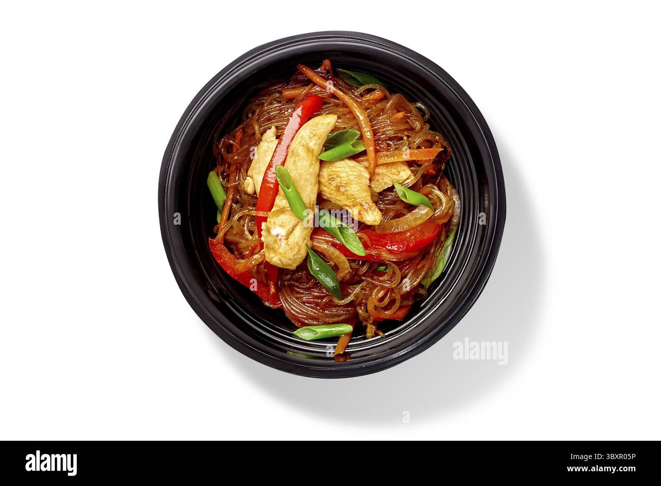 Ciotola di deliziosi spaghetti di riso fritti con pollo, peperoni, carote e cipolle verdi, vista dall'alto isolata su sfondo bianco. Popolare Cinese Foto Stock