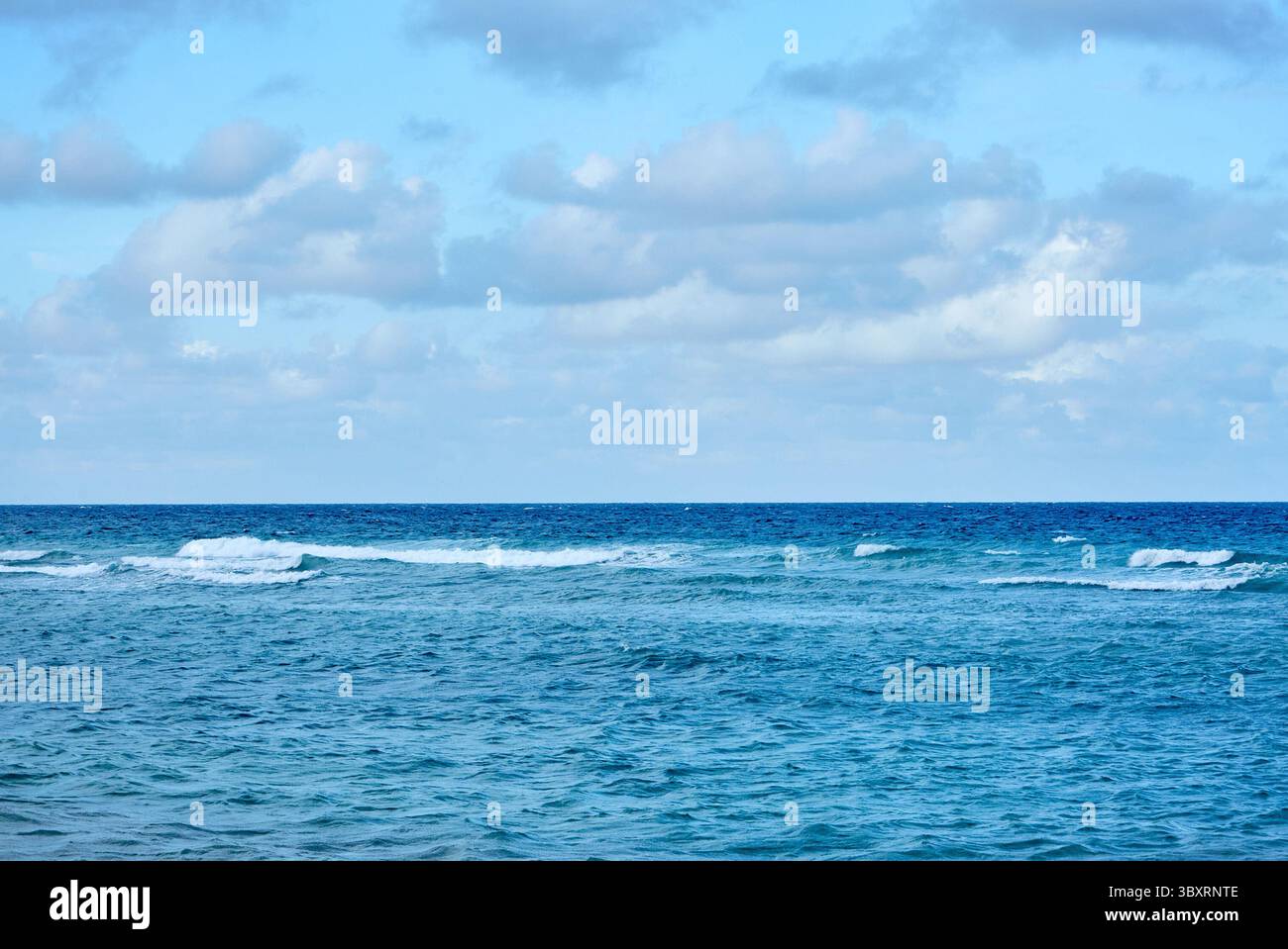 Blue Sky e Small Ocean Waves on the Horizon Foto Stock