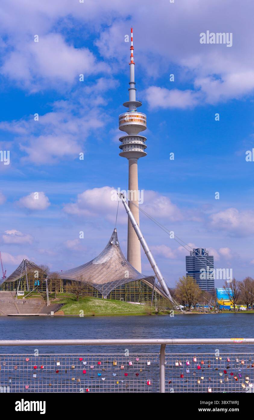 Monaco, Germania - 2 aprile 2025: Olympiapark (parco olimpico), Olympiasee (lago olimpico) e Olympiaturm (torre olimpica) a Monaco, Baviera, Germania, UE Foto Stock