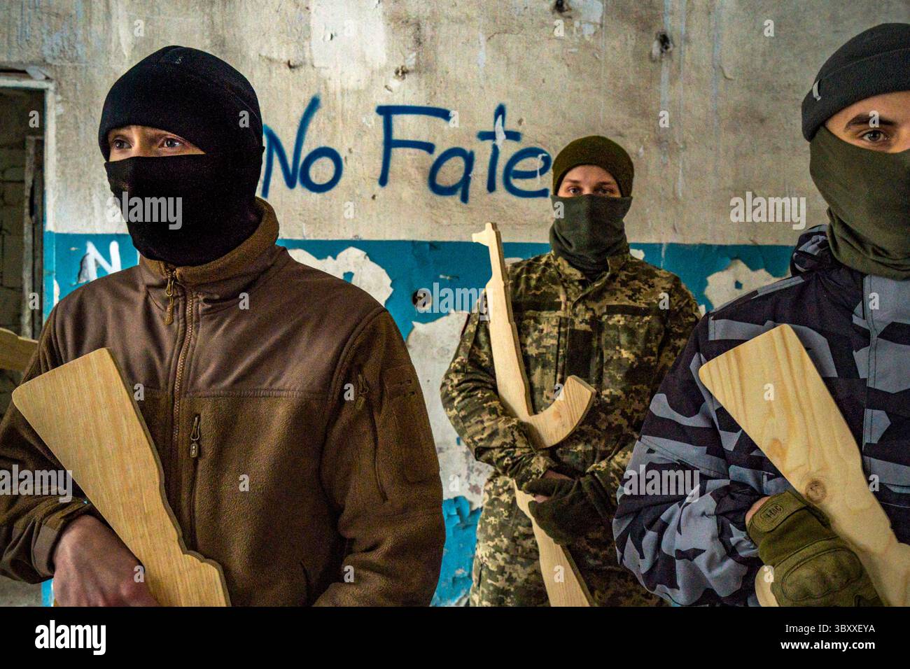 6 febbraio 2022, Kiev, Ucraina: Volontari civili per la Brigata di difesa territoriale di Kiev con fucili di addestramento in legno in un'esercitazione militare all'interno di un edificio con la parola "No fate" sul muro alla periferia della città. Secondo i funzionari statunitensi, la Russia ha già collocato circa il 70% delle forze militari necessarie per un'invasione su vasta scala dell'Ucraina nelle aree confinanti. (Immagine di credito: © Celestino Arce Lavin/ZUMA Press Wire) Foto Stock