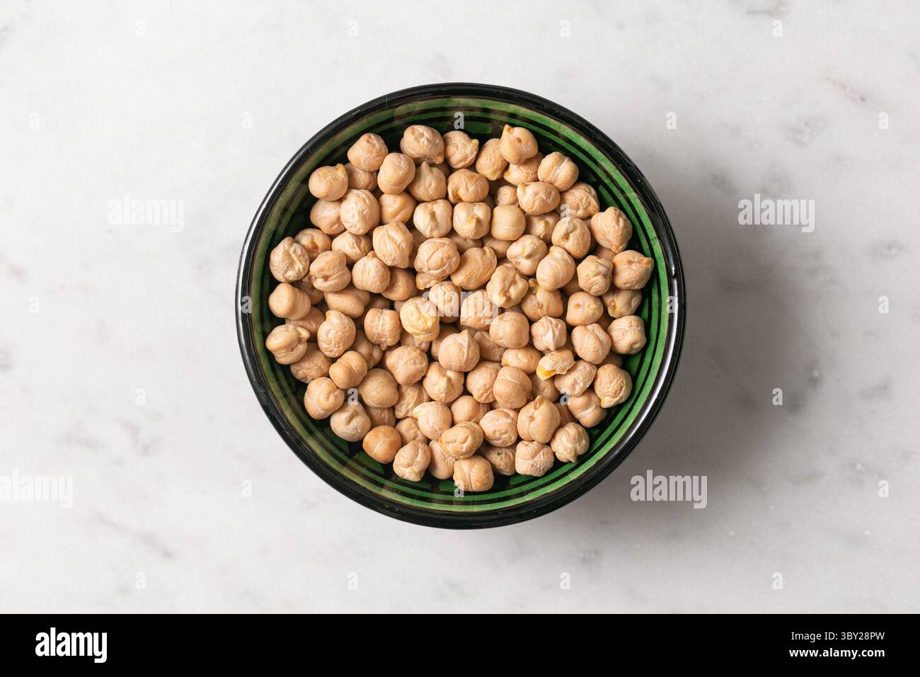 Ciotola di ceci su marmo. Cibo proteico vegano sano. Ingrediente di legumi organici. Vista dall'alto dei ceci secchi. Base di cottura vegetariana. Foto Stock