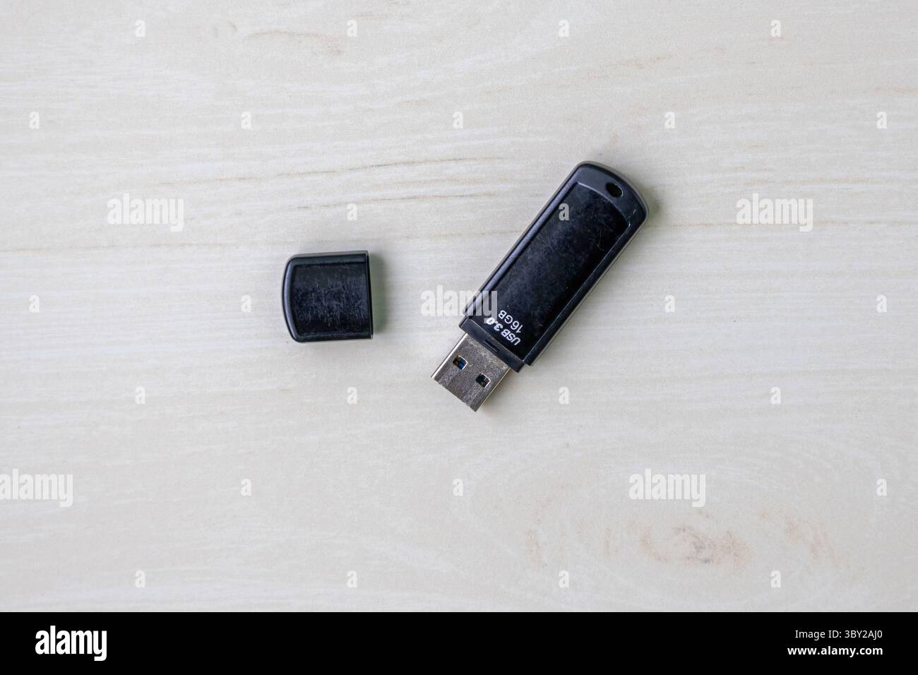Moderna porta USB 3,0 nera Pendrive da 16 GB con vista dall'alto su una scrivania in legno chiaro. Foto Stock