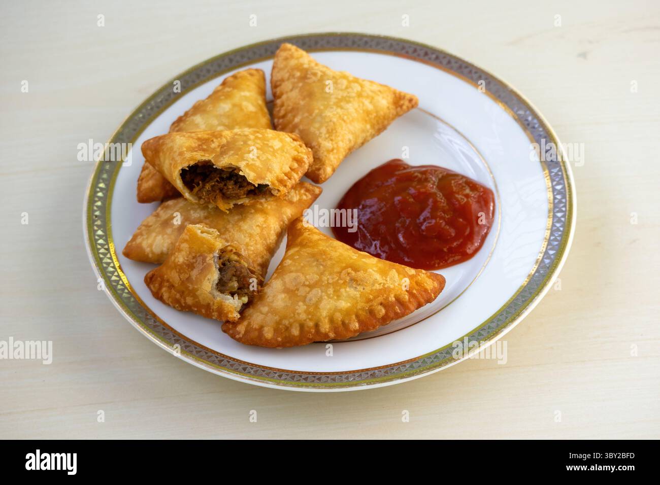 Piatto di deliziosi samosas di manzo con salsa di pomodoro. Popolare snack croccante in Bangladesh, Pakistan, India. Noti anche come Samsa, Sambosas, Sambusak, Foto Stock
