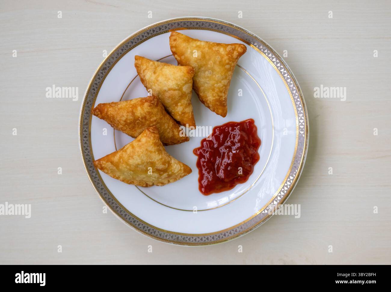 Deliziosi samosa di manzo con salsa di pomodoro su un piatto. Popolare cibo bengalese, pakistano e indiano. Saporiti samsa, sambosa, sambusak, S. Foto Stock