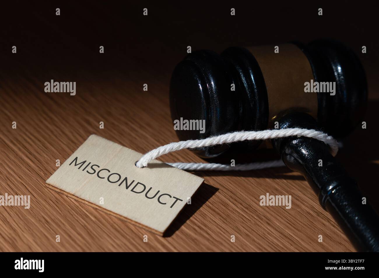 Un martelletto e un cartellino con la parola "CATTIVA CONDOTTA”. Concetto legale e giudiziario. Foto Stock