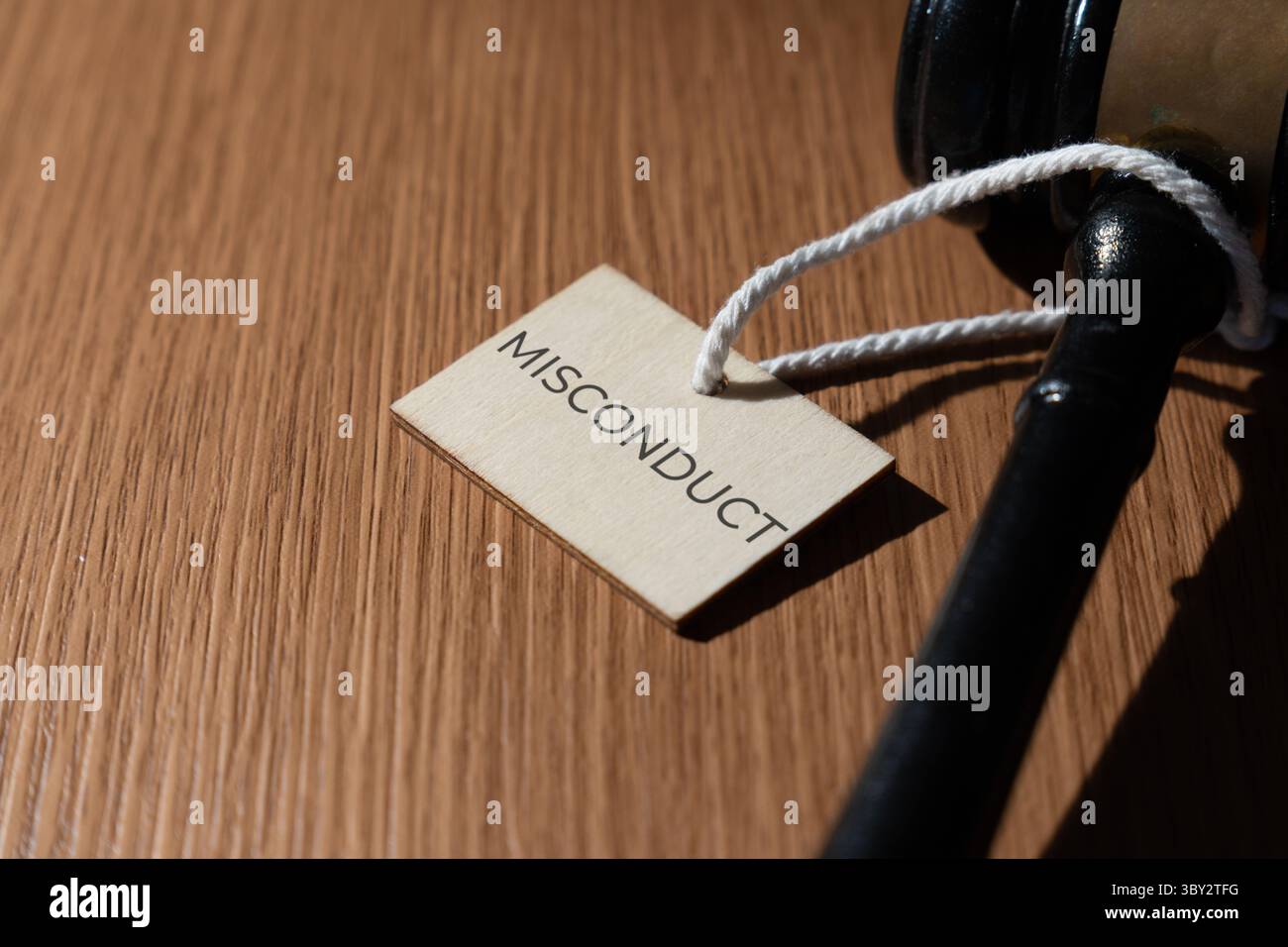 Un martelletto e un cartellino con la parola "CATTIVA CONDOTTA”. Concetto legale e giudiziario. Foto Stock