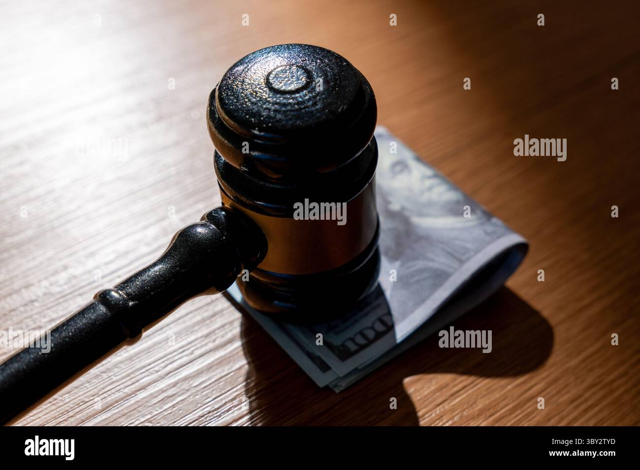Una pila di banconote da cento dollari e un martelletto. Corruzione, corruzione o transazioni legali che coinvolgono il concetto di denaro. Foto Stock
