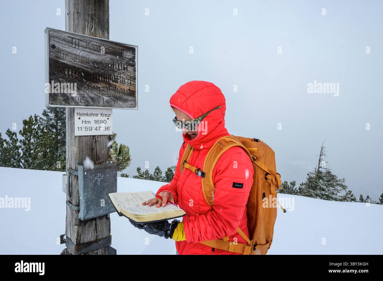 Woman hiking, firma del libro sulla vetta, Schönfeldjoch, Mangfall Mountains, Tirolo, Austria Foto Stock