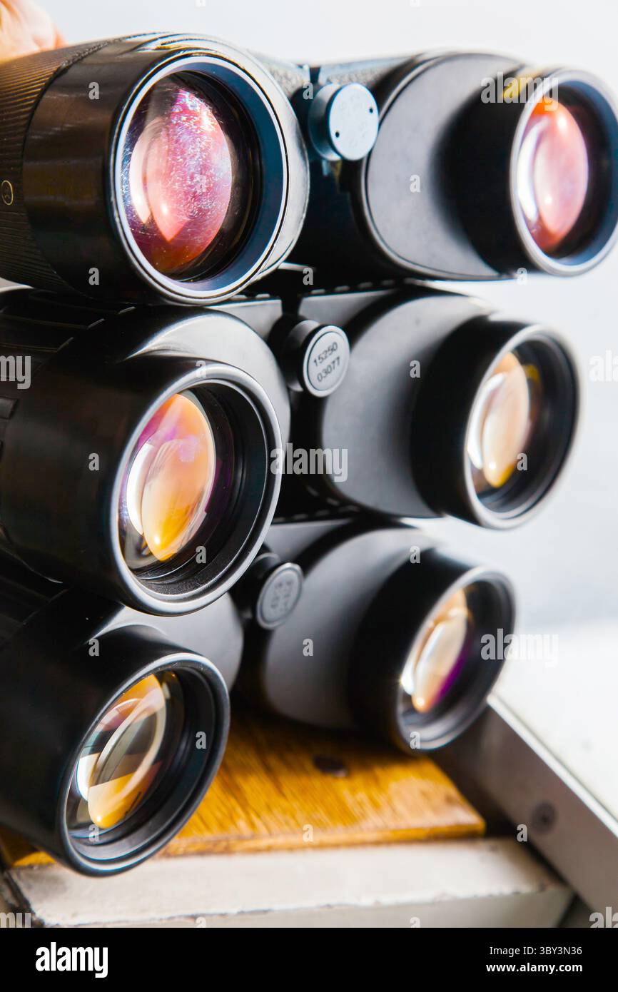 Diversi binocoli su un ponte navale vicino all'oblò. Foto Stock