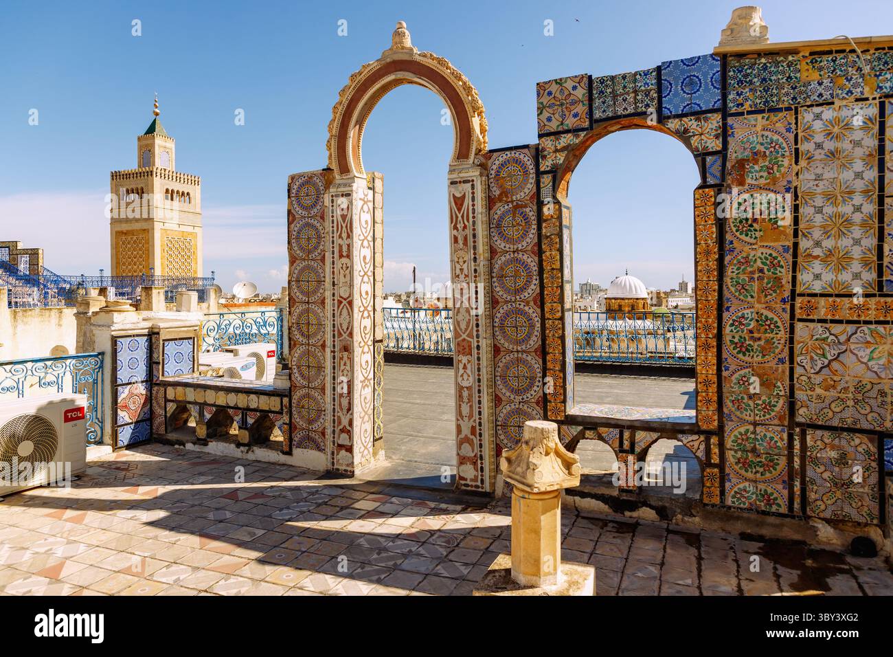 Terrazza sul tetto decorata con piastrelle colorate che si affaccia sulla grande Moschea Djamaa ez-Zitouna nella Medina di Tunisi, Tunisia Foto Stock