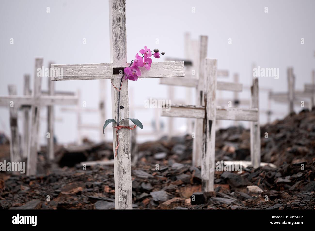 Diverse croci e fiori di plastica segnano un cimitero fuori Ittoqqortoormiit, Groenlandia orientale, Groenlandia Europa Foto Stock