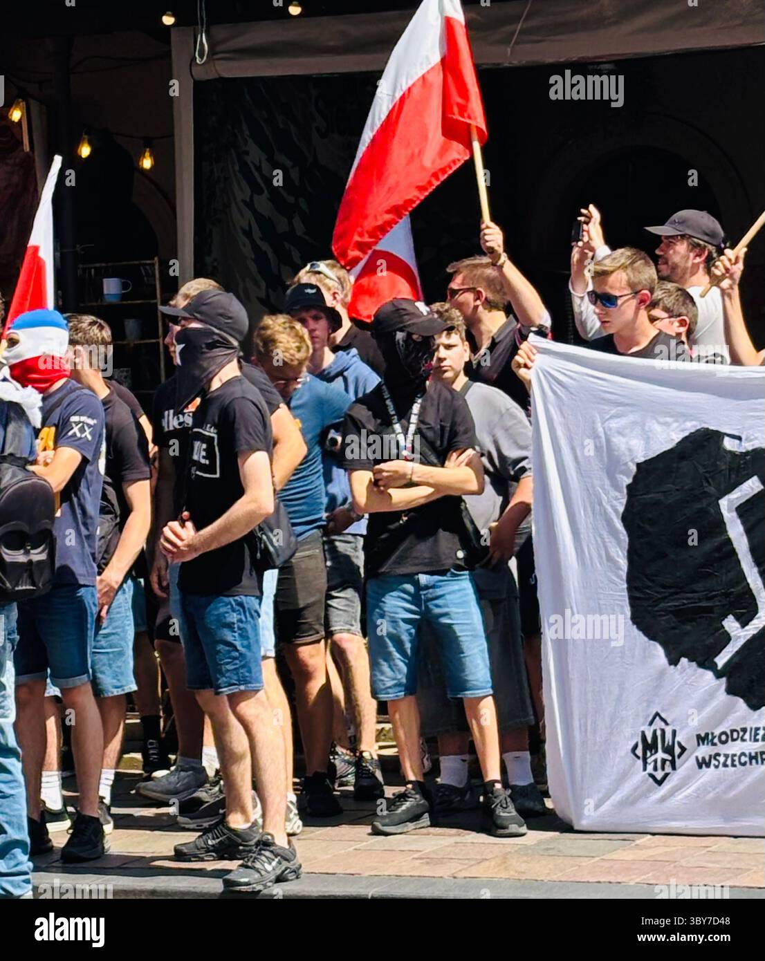 Una manifestazione di estrema destra contro l'immigrazione di fronte al consolato tedesco a Cracovia, in Polonia. - Immagine stock catturata con smartphone
